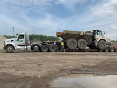 KLF hauling heavy equipment on a low-boy trailer